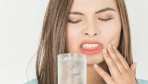 woman touching jaw in pain